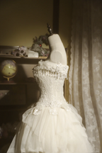 White strapless ball gown with a cinched waist and a voluminous tiered cake skirt; bridal gown R7289