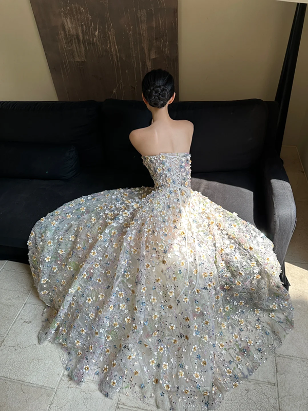 Sheer white base with appliqué, strapless, waist‑cinched, slim‑fit, long ball gown with a voluminous ruffled skirt R8015